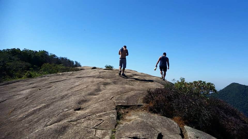 Panoramic view from Pedra Bonita summit showing Rio de Janeiro's coastline, Tijuca Forest, and surrounding mountains during a guided hiking tour