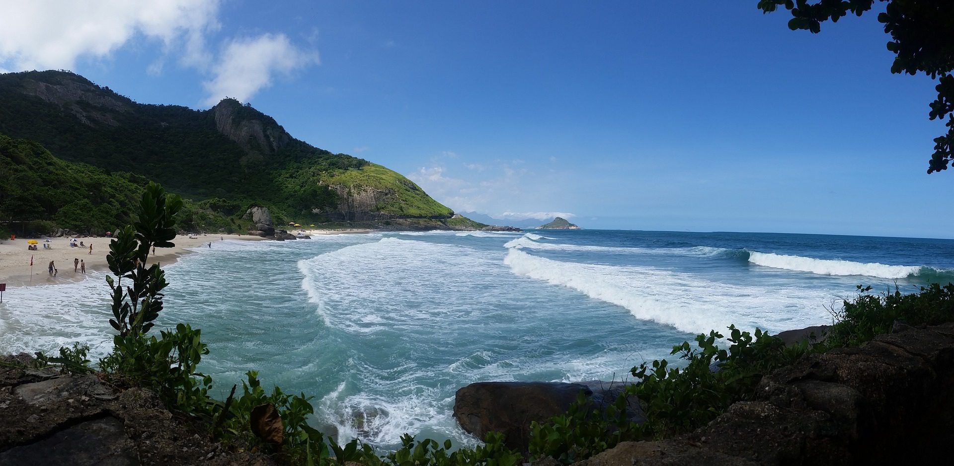 Grumari Beach in Rio de Janeiro featuring dramatic mountain backdrop, clear turquoise waters, and pristine white sand beach within protected natural reserve