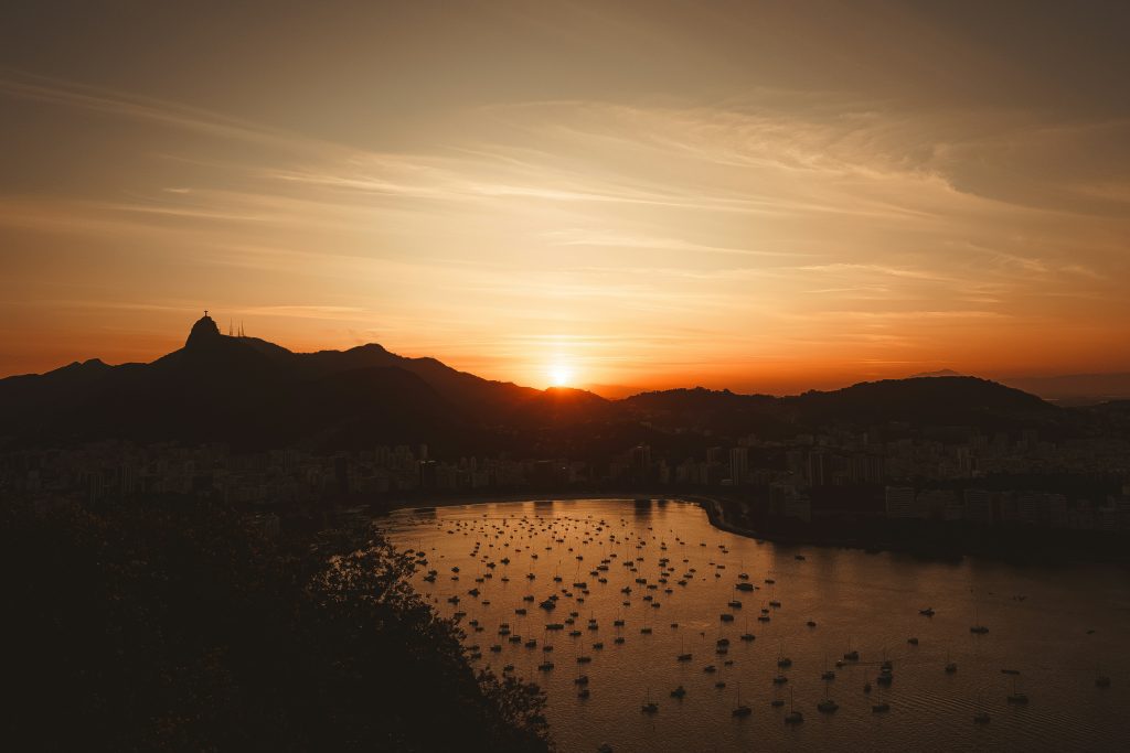 Sugarloaf Mountain at sunset in Rio de Janeiro with golden sky over Guanabara Bay and cable car