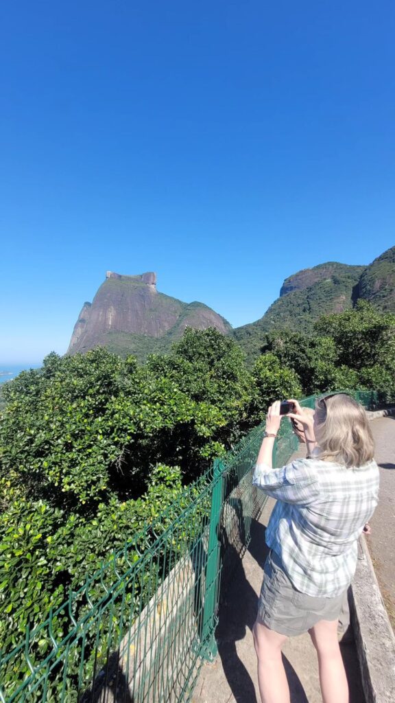 Traveler photographing Pedra da Gávea from a viewpoint in Tijuca National Park on a multi-day tour in Rio