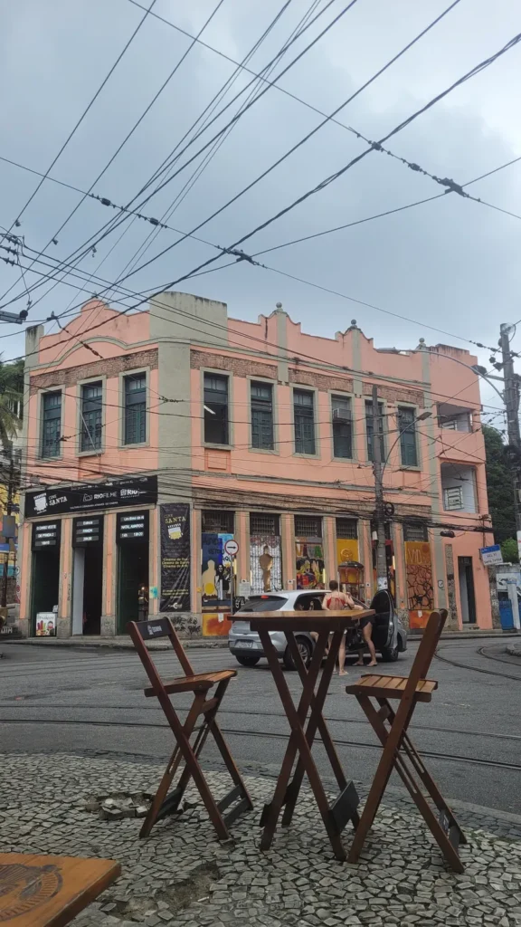 Sidewalk bar table facing the historic Cine Santa building and tram tracks in Santa Teresa, Rio de Janeiro