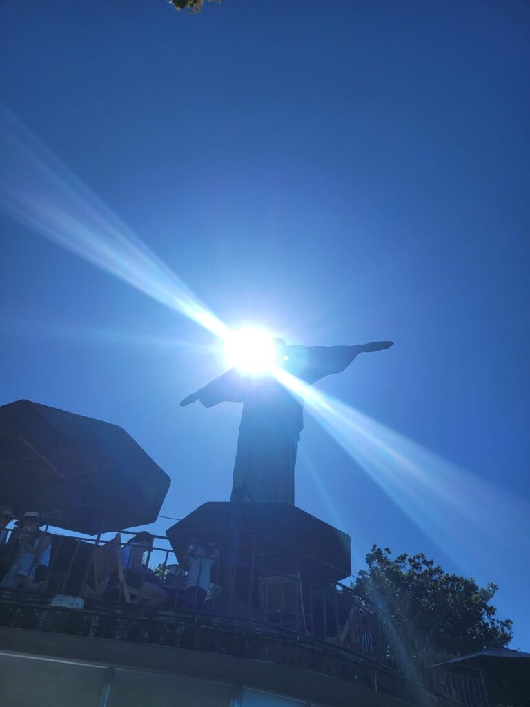 Christ the Redeemer from behind, silhouetted against the sun on Corcovado
