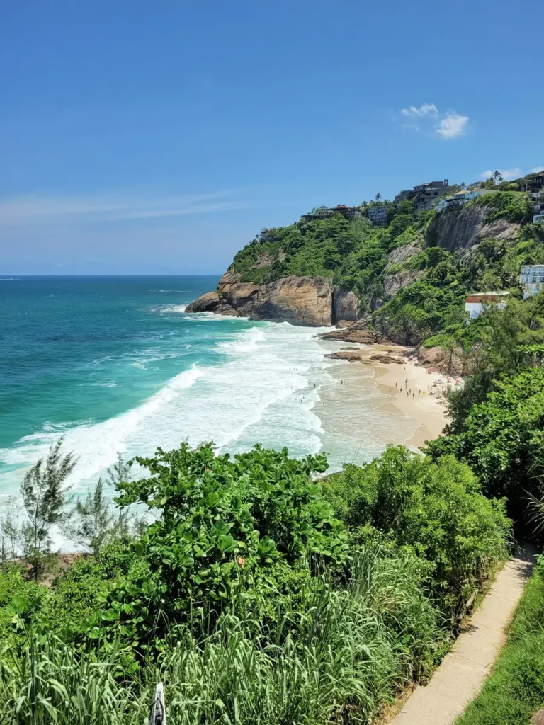 Turquoise waves and a small sandy cove at Joatinga beach, one of Rio's off the beaten path beaches