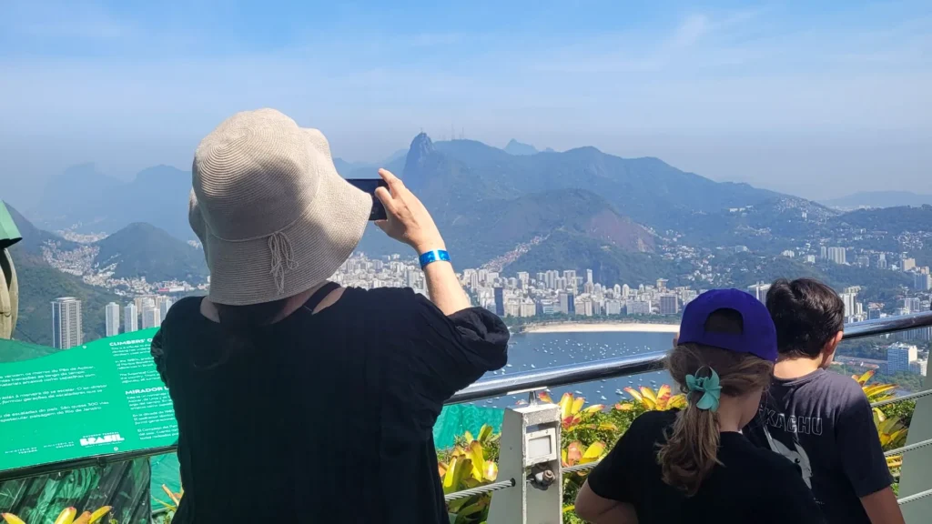 Family on a last minute tour in Rio taking photos of Christ the Redeemer and Botafogo Bay from Sugarloaf Mountain