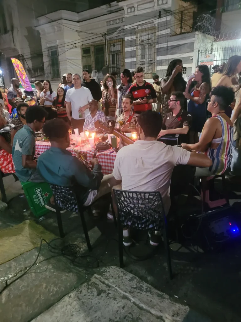 Locals gathered around a street samba circle at night in Rio de Janeiro, musicians playing at a table with candles - Rio de Janeiro like a local