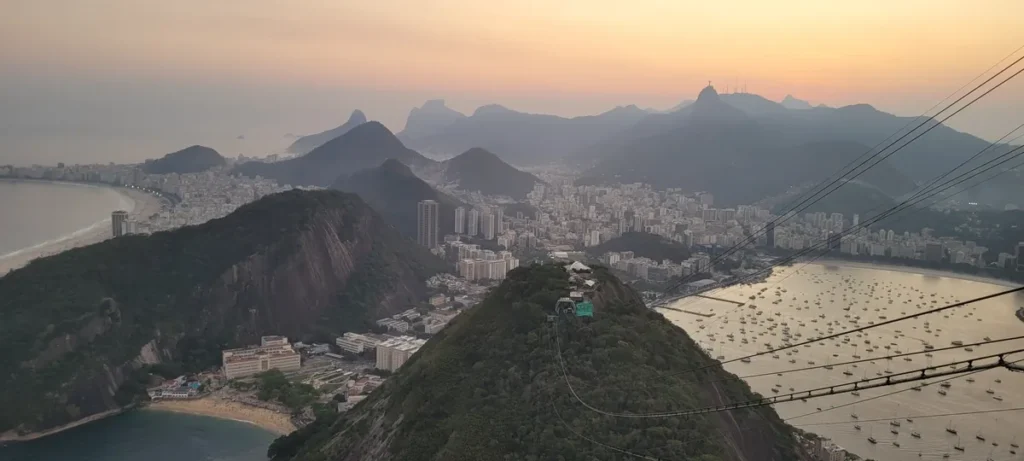 Golden-hour view of Copacabana, Botafogo Bay and the cable car line from the top of Sugar Loaf